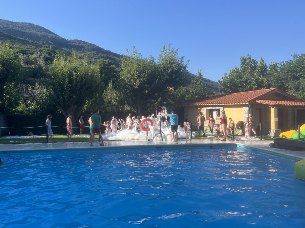 Fiesta de la espuma al aire libre con colchonetas acuáticas junto a la piscina en camping rio Jerte.
