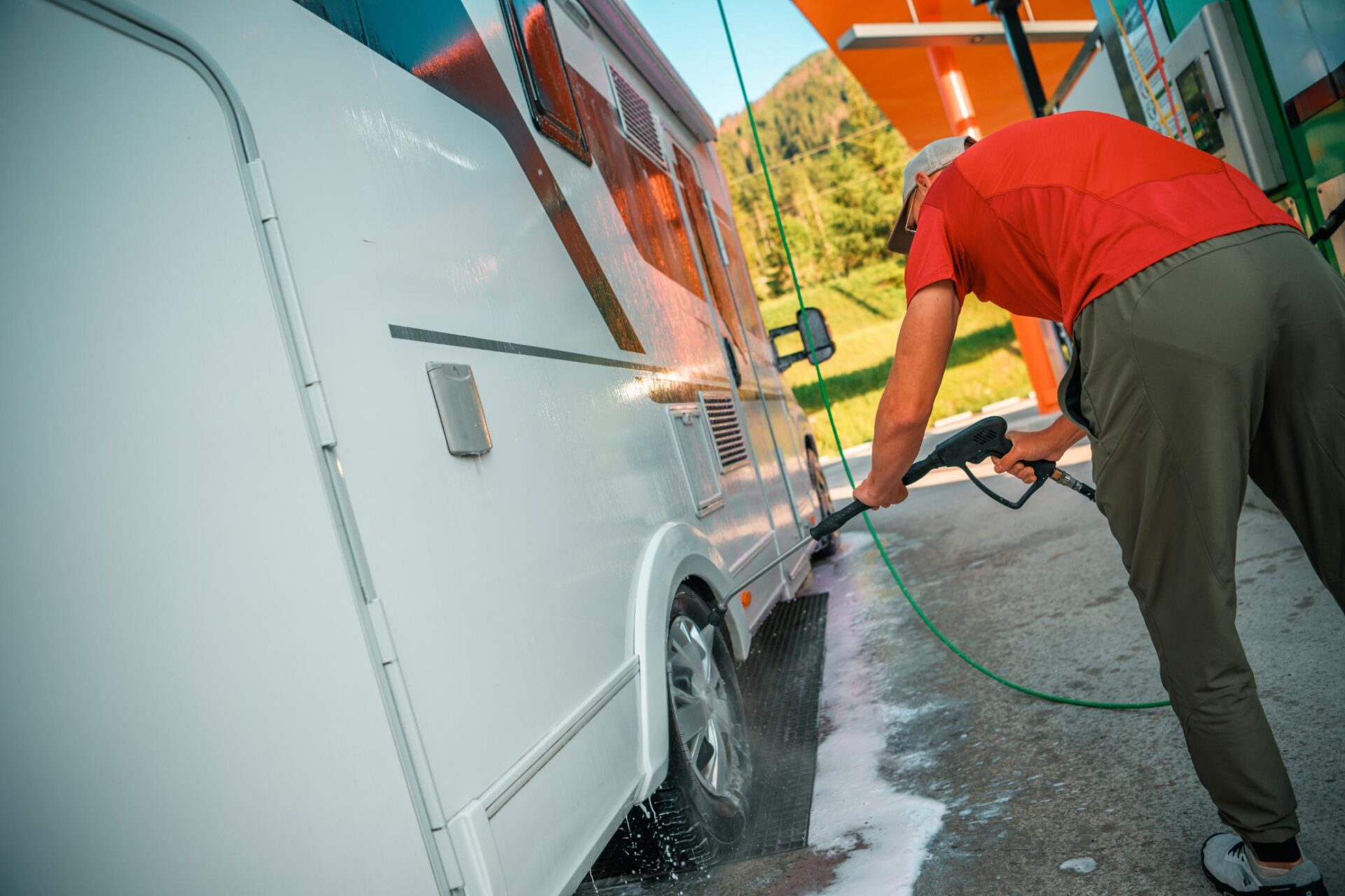 Hombre limpiando su caravana en camping río Jerte