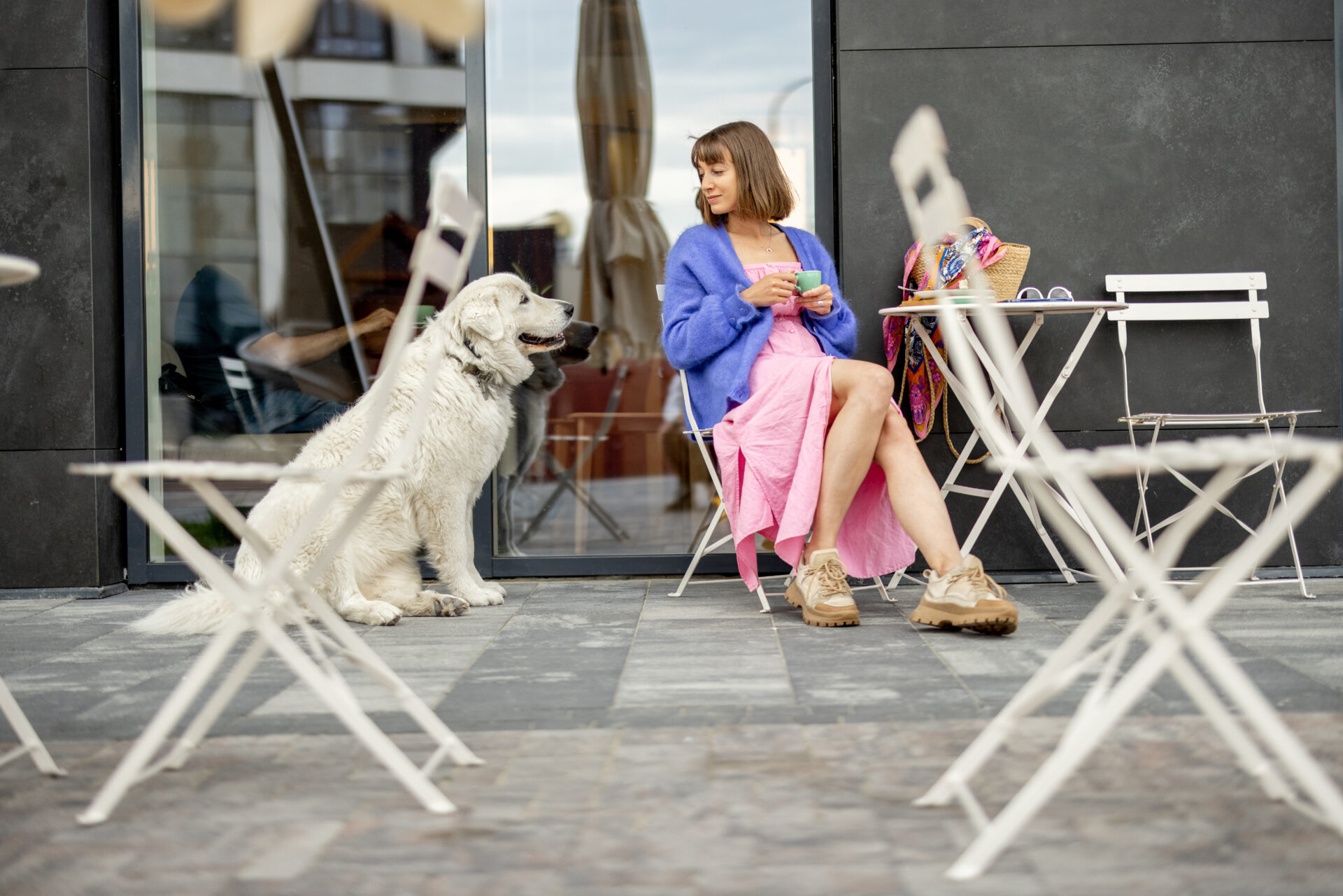 Mujer tomando un café con su perro en la terrasa